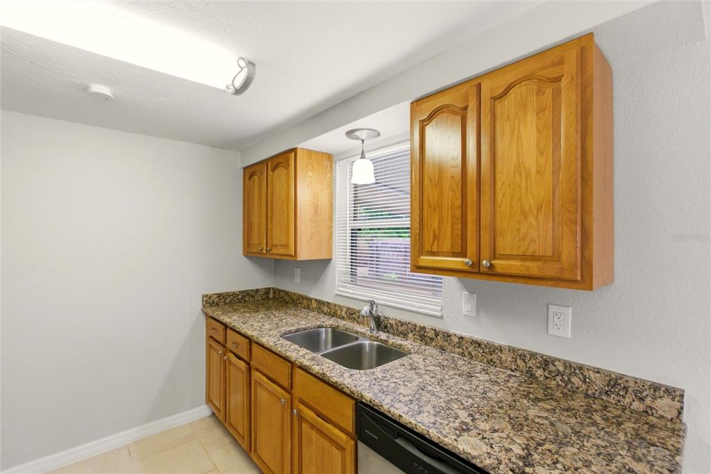 1107 Seneca Road Venice, FL 34293 - Photo 10 of 30 a kitchen with a sink a stove and cabinets