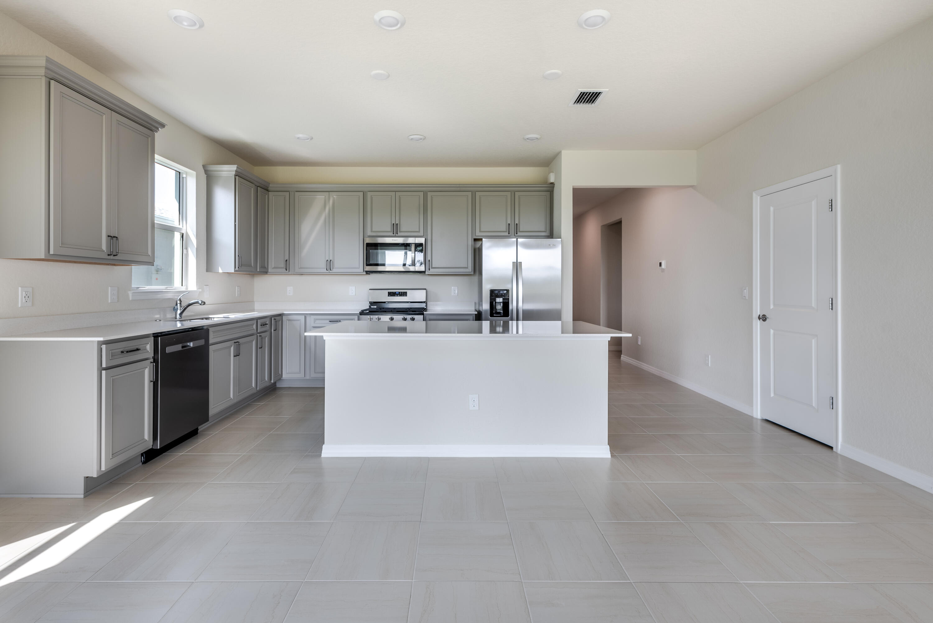 12327 Southwest Sand Dollar Way Port St. Lucie, FL 34987 - Photo 24 of 29 a view of kitchen with stainless steel appliances a sink a stove a refrigerator cabinets and a window