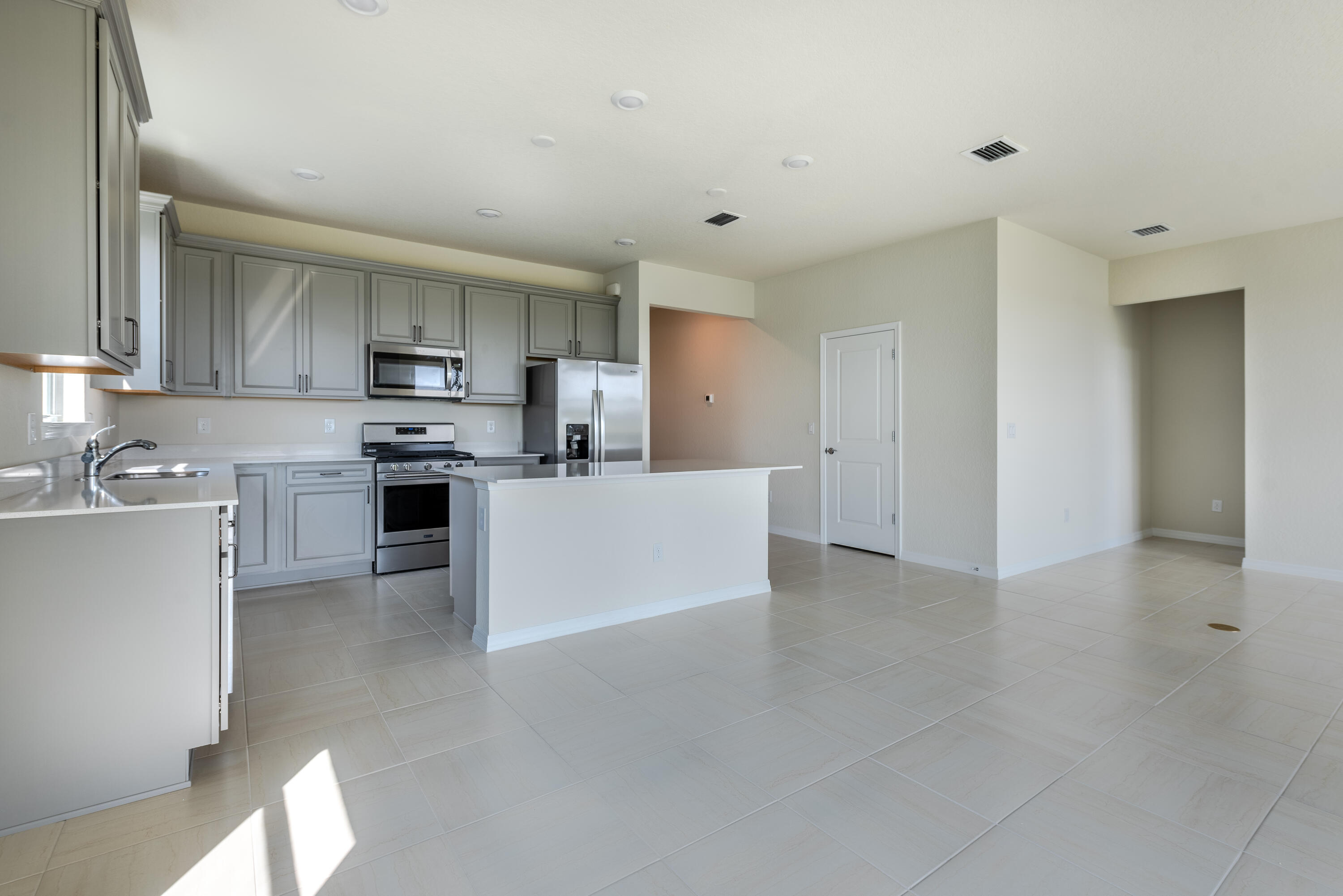 12327 Southwest Sand Dollar Way Port St. Lucie, FL 34987 - Photo 25 of 29 a large white kitchen with cabinets and stainless steel appliances