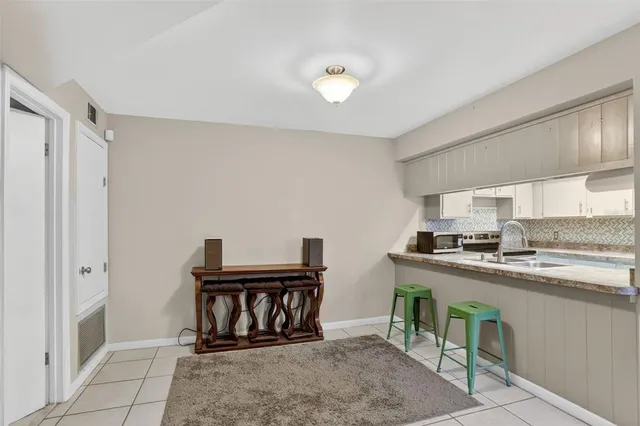 a kitchen with kitchen island a stove a table and chairs in it