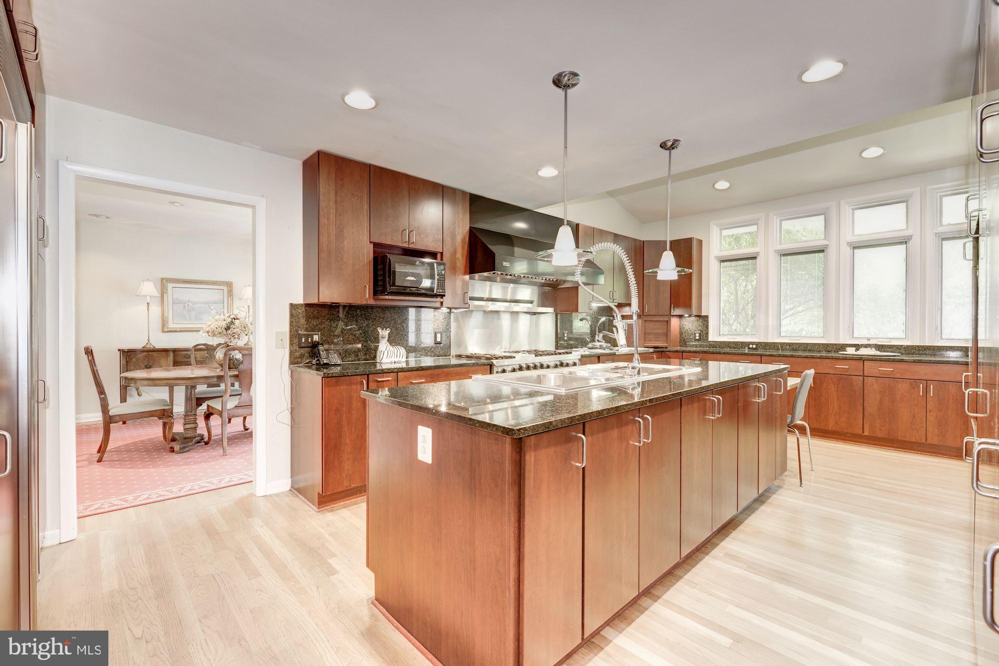 6129 Overlea Road Bethesda, MD 20816 - Photo 18 of 30 a large kitchen with kitchen island a large counter top space a sink stainless steel appliances and cabinets