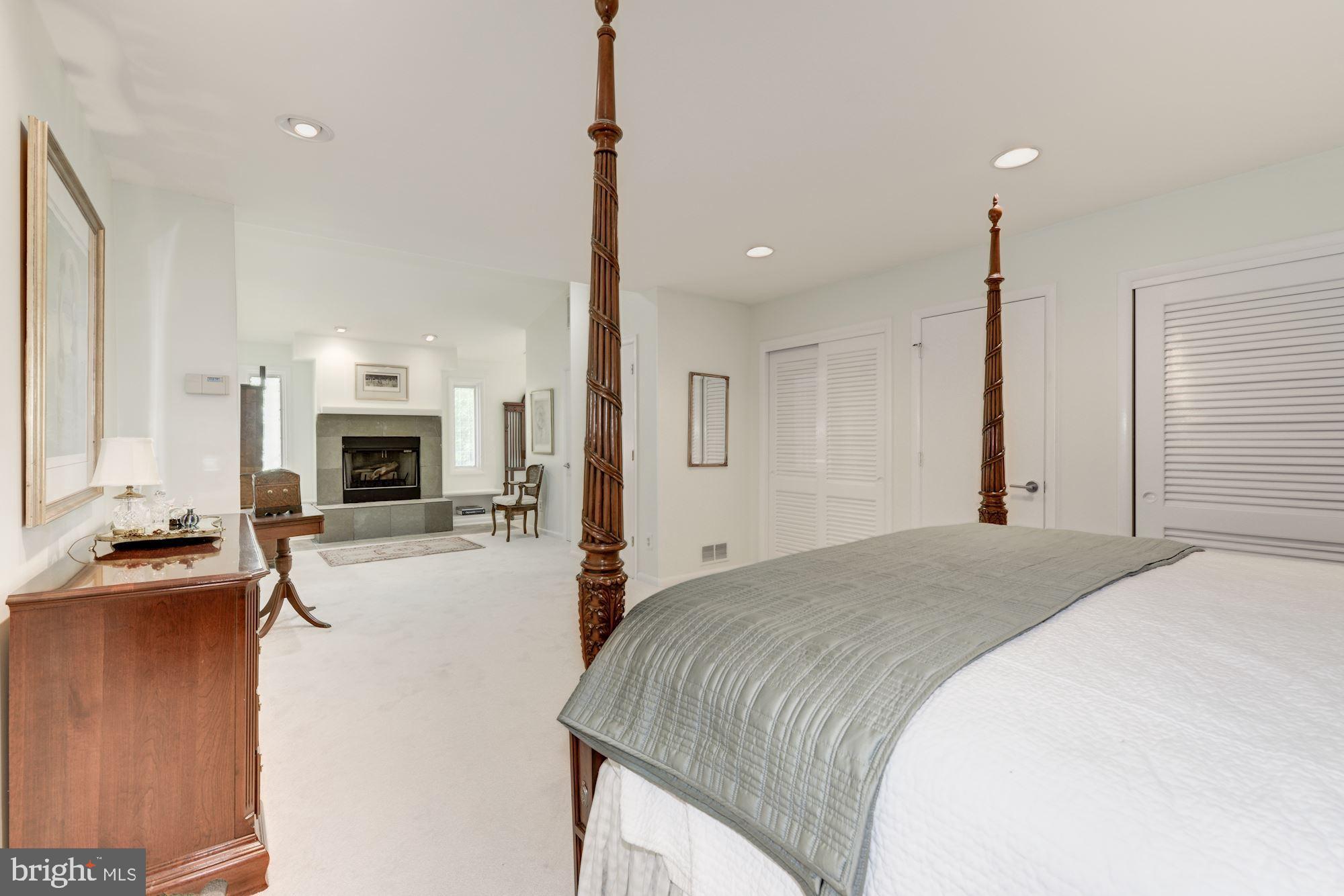 6129 Overlea Road Bethesda, MD 20816 - Photo 23 of 30 a spacious bedroom with a bed and a flat screen tv