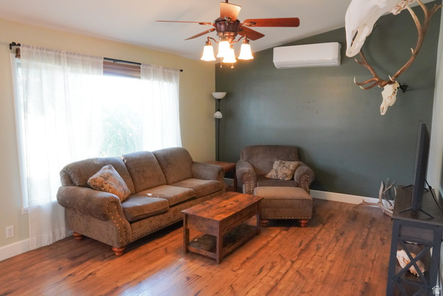324 Stringtown Road Georgetown, ID 83239 - Photo 7 of 49 Living area with lofted ceiling, a wall mounted air conditioner, hardwood / wood-style floors, and ceiling fan
