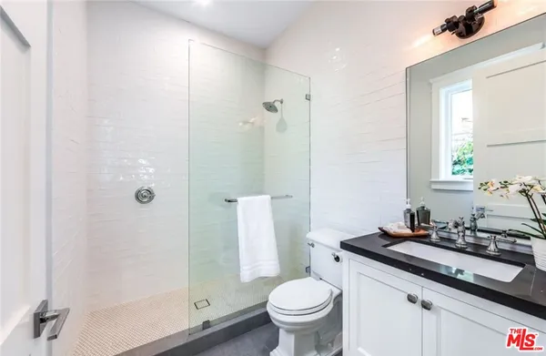 a bathroom with a granite countertop sink toilet and shower