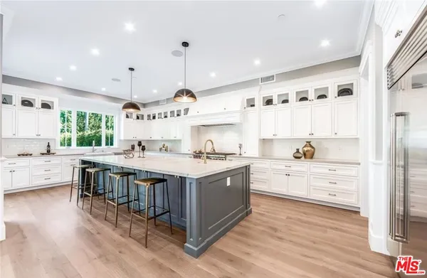 a large kitchen with a large window and white cabinets