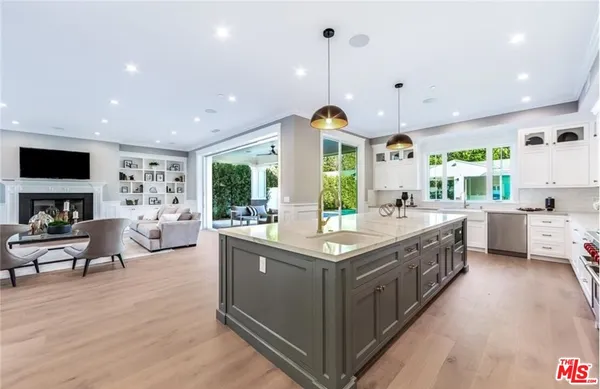 a kitchen with stainless steel appliances granite countertop a lot of counter space and a wooden floor
