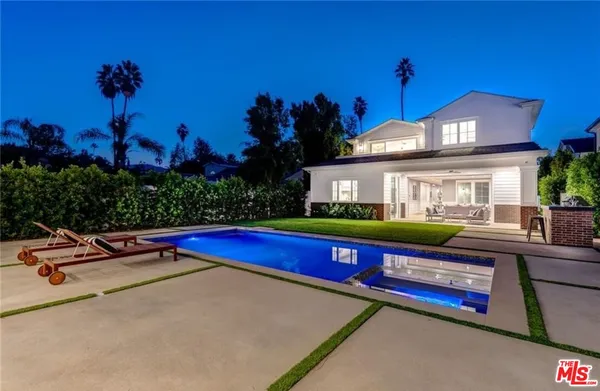 a front view of a house with yard and swimming pool