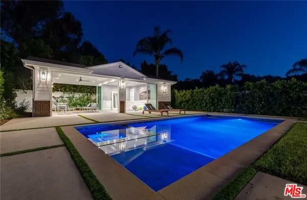 a view of swimming pool with outdoor seating and yard in back