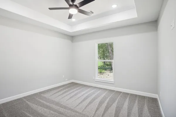 an empty room with a window and ceiling fan