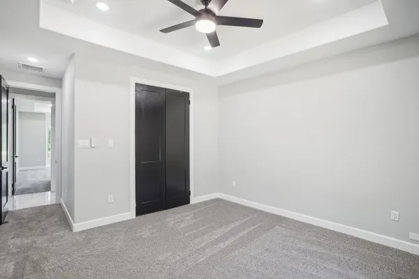 an empty room with closet and fan