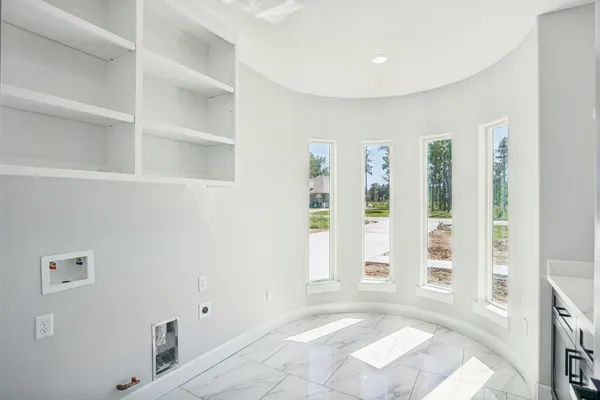 a view of an empty room with window and hardwood floor