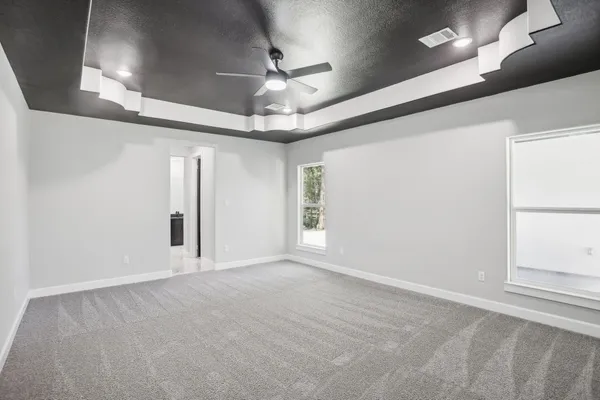 en empty room with windows and ceiling fan