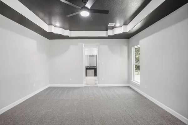 en empty room with windows and ceiling fan