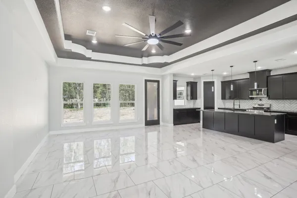 a large white kitchen with a large window cabinets and stainless steel appliances