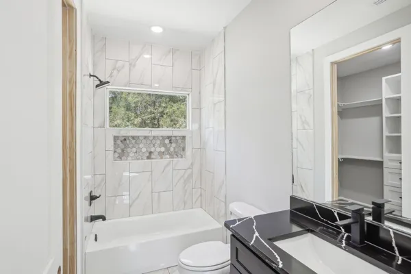 a bathroom with a granite countertop sink toilet and shower