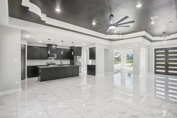 a large white kitchen with a large counter top appliances and cabinets