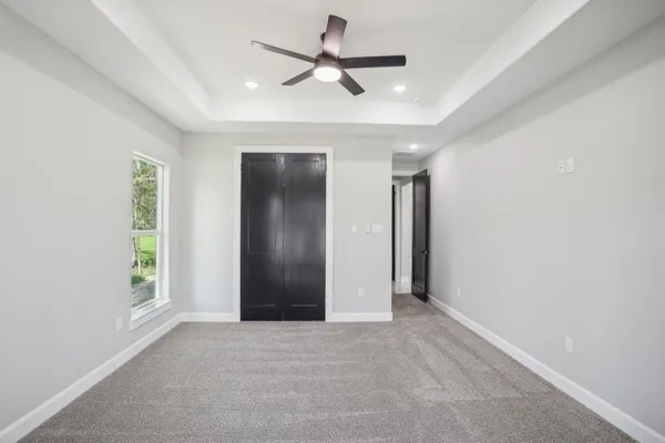 an empty room with fan and windows