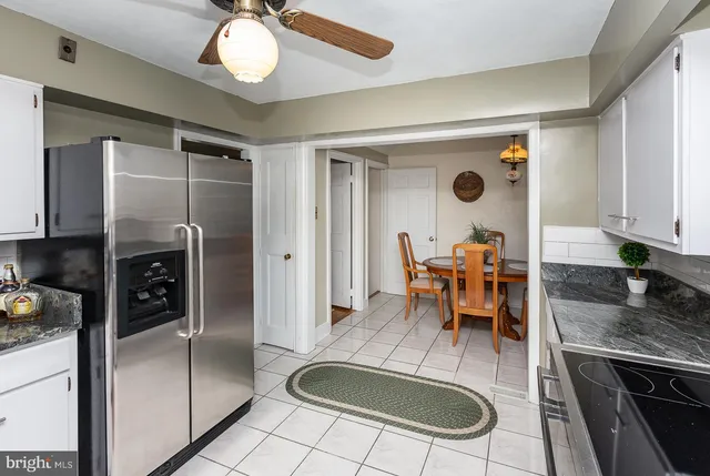 a kitchen with stainless steel appliances granite countertop a refrigerator a stove and a sink with granite countertops