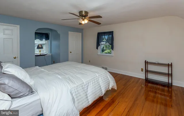 a bedroom with a bed and a wooden floor