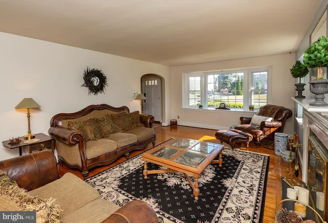 a living room with furniture a rug and a large window