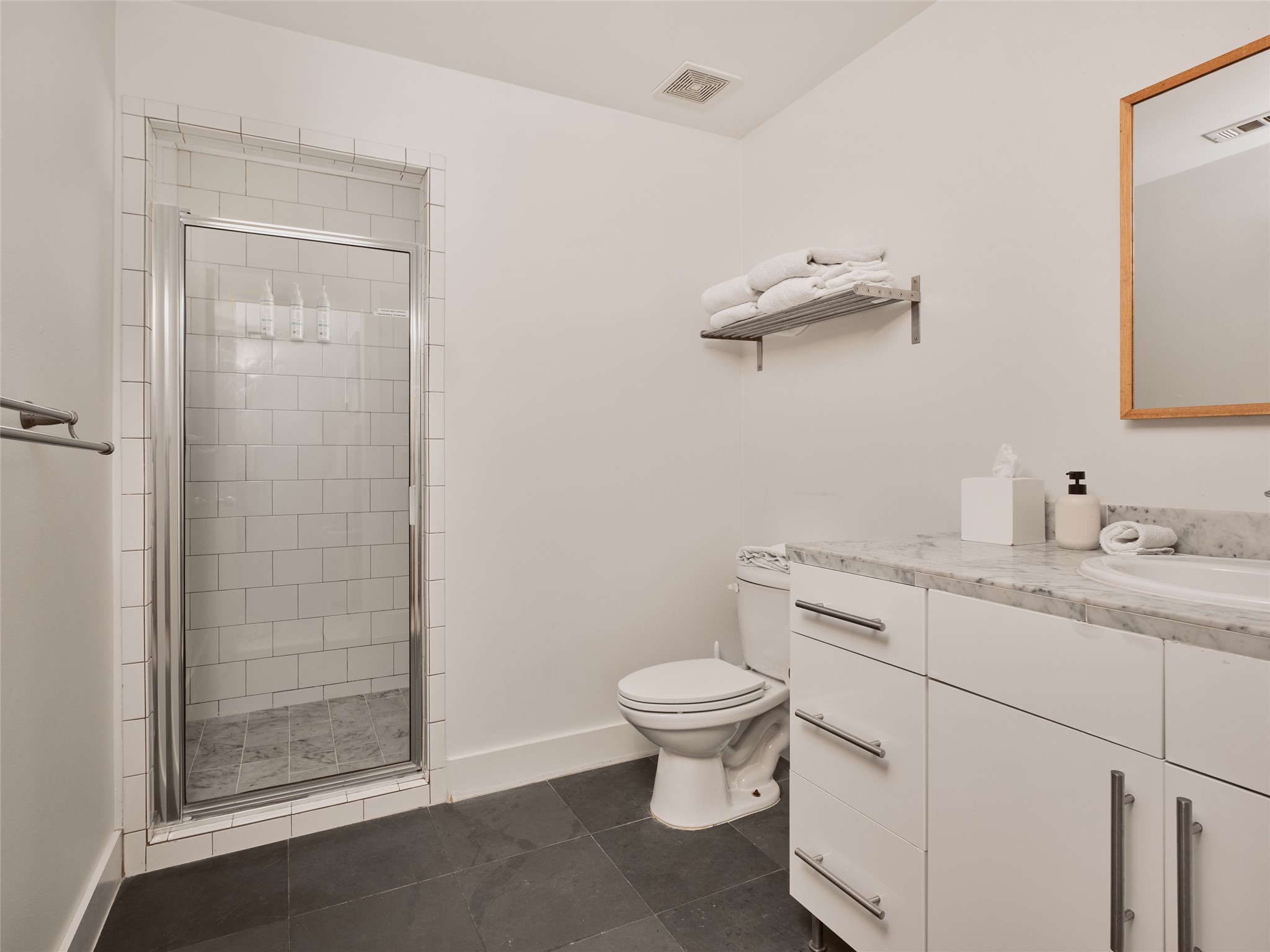 2002 East 13th Street, Unit A Austin, TX 78702 - Photo 26 of 37 Bathroom with vanity, a shower stall, and dark tile patterned flooring