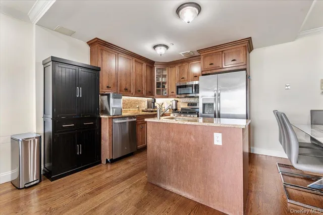 a kitchen with kitchen island wooden cabinets and stainless steel appliances