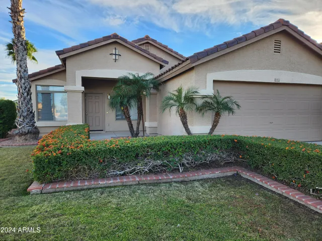 a front view of a house with a garden and yard