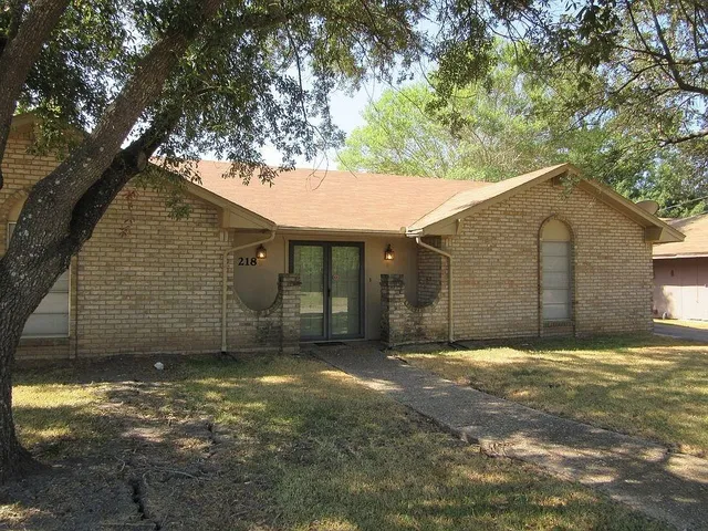 a view of a house with a yard and a tree