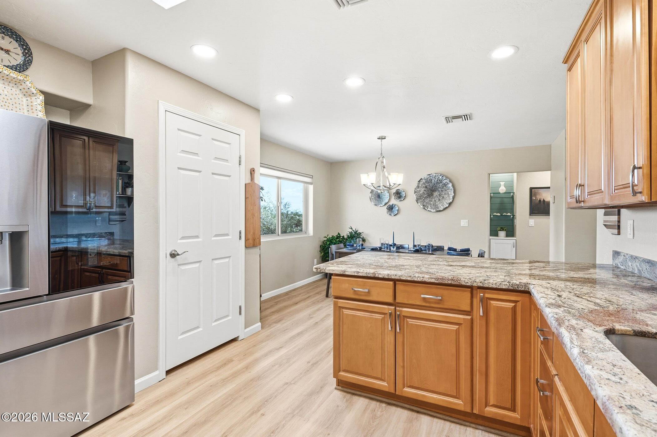 13599 East Rincon Ranch Road Vail, AZ 85641 - Photo 16 of 41 a large kitchen with granite countertop a lot of counter space and wooden floor