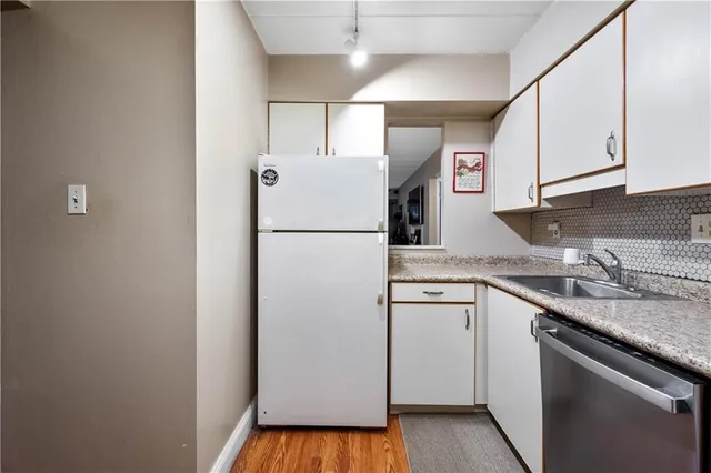 a kitchen with a sink a refrigerator a counter top space and cabinets