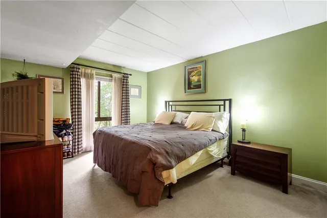 a bed sitting in a spacious bedroom next to a window