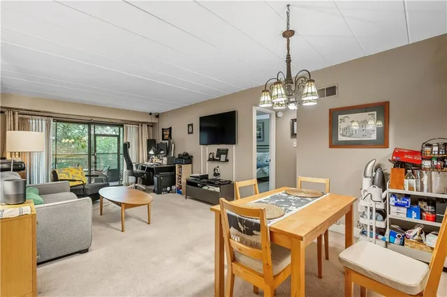 a living room with furniture a flat screen tv and a chandelier
