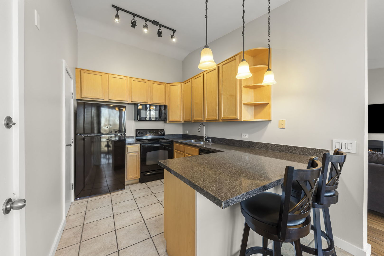 6010 Forest View Road, Unit 3A Lisle, IL 60532 - Photo 9 of 20 a kitchen with granite countertop a refrigerator a stove a sink and white cabinets with wooden floor