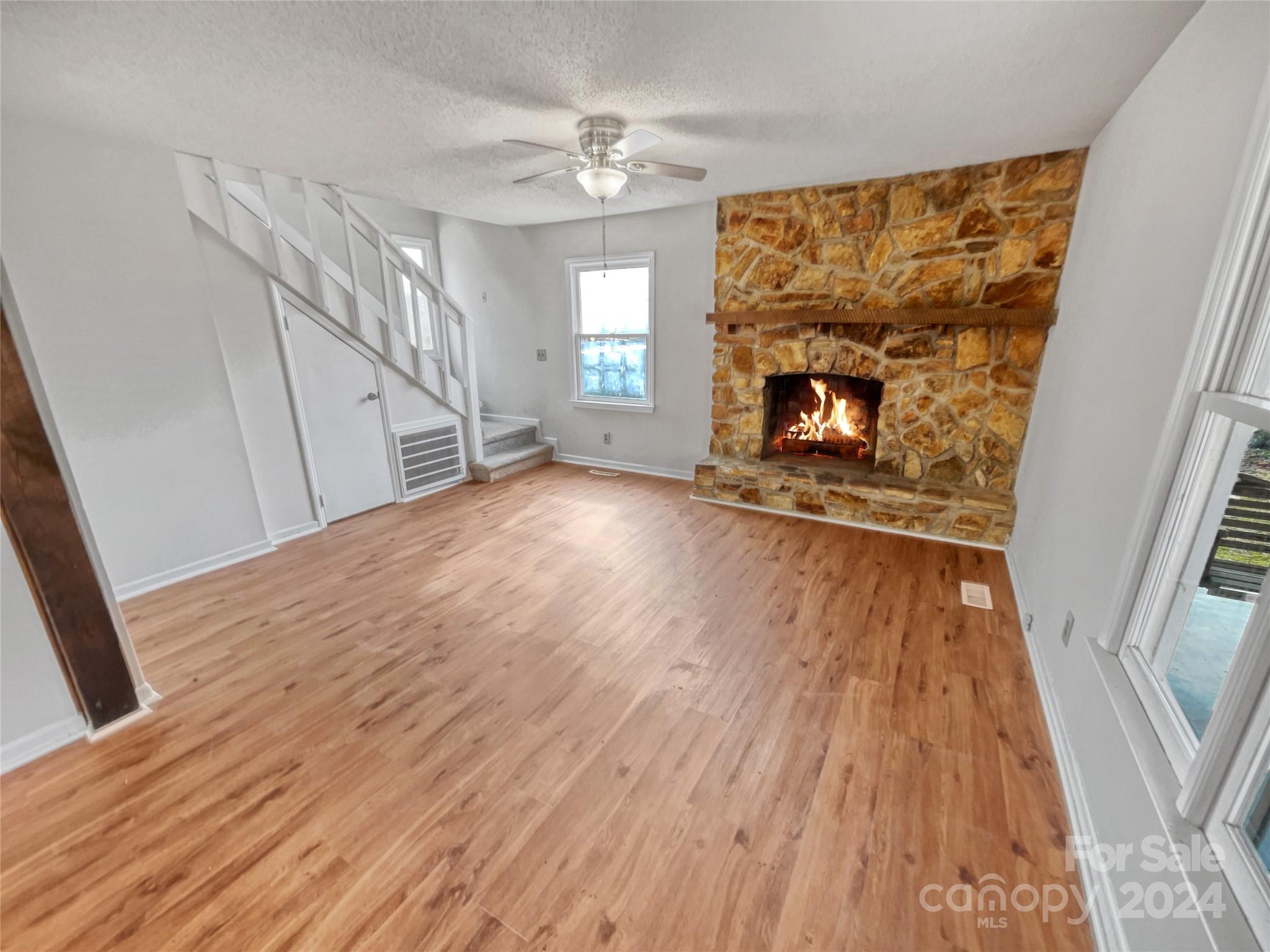 506 Ralph Handsel Boulevard Stanley, NC 28164 - Photo 3 of 18 a view of an empty room with wooden floor fireplace and a window