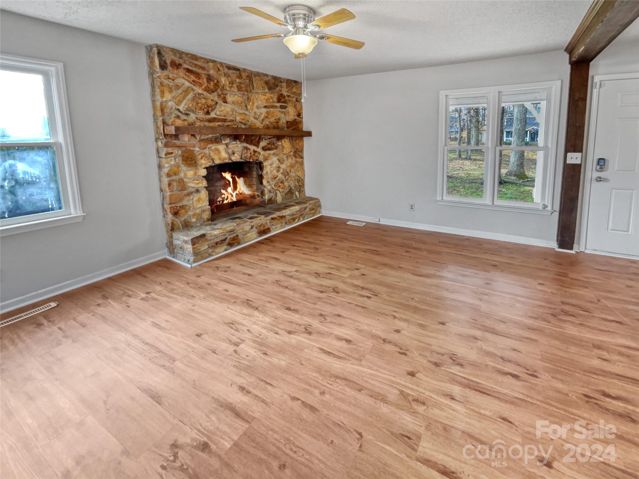 506 Ralph Handsel Boulevard Stanley, NC 28164 - Photo 7 of 18 wooden floor fireplace and windows in an empty room