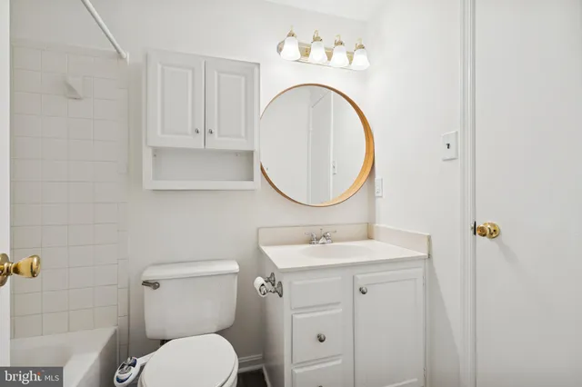a bathroom with a sink mirror and toilet