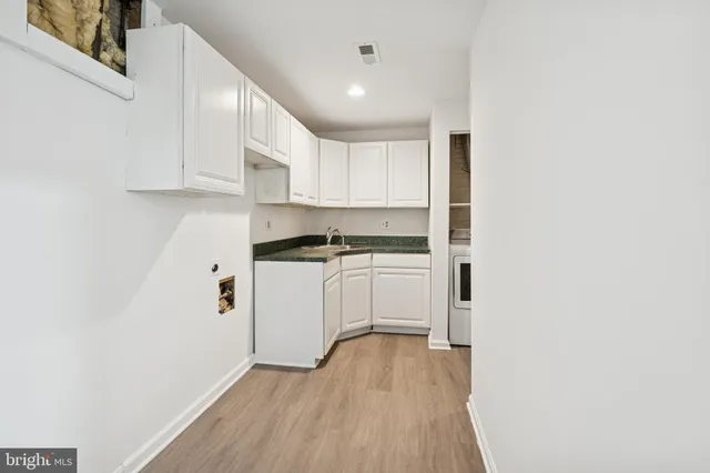 a kitchen with white cabinets and white appliances