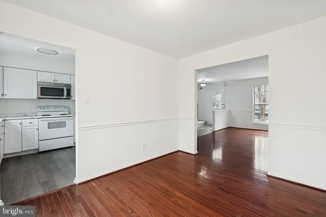 a view of a kitchen with wooden floor and electronic appliances