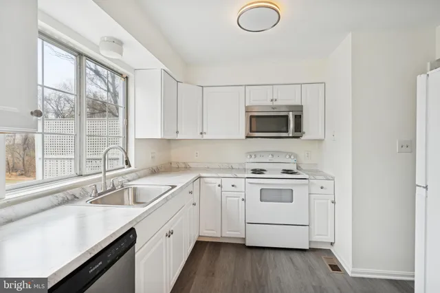 a kitchen with a sink stove and microwave