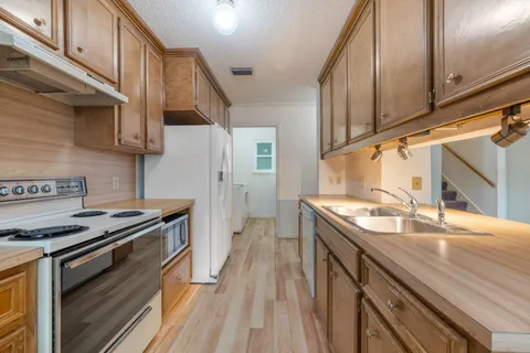 a kitchen with a sink stove top oven and cabinets