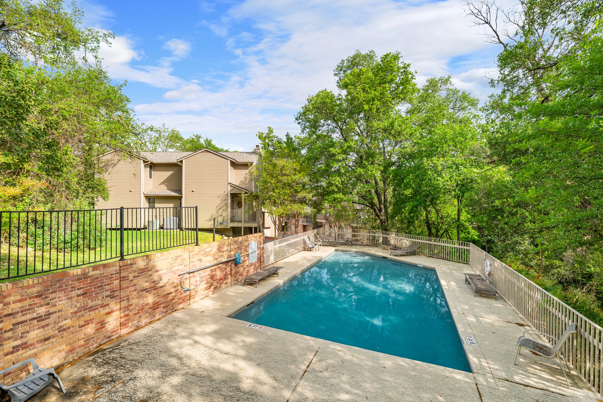 3845 Ranch Road 2222, Unit 19 Austin, TX 78731 - Photo 28 of 38 Surrounded by fencing and trees, the pool area remains a quiet retreat for residents