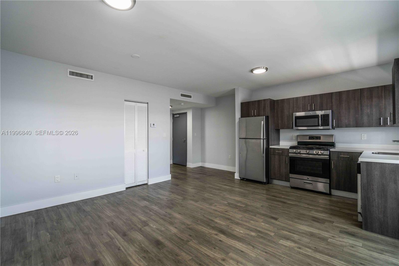 331 85th Street, Unit 17 Miami Beach, FL 33141 - Photo 4 of 16 a kitchen with stainless steel appliances a refrigerator and a stove top oven