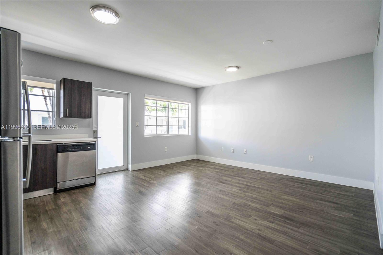 331 85th Street, Unit 17 Miami Beach, FL 33141 - Photo 5 of 16 an empty room with wooden floor and windows
