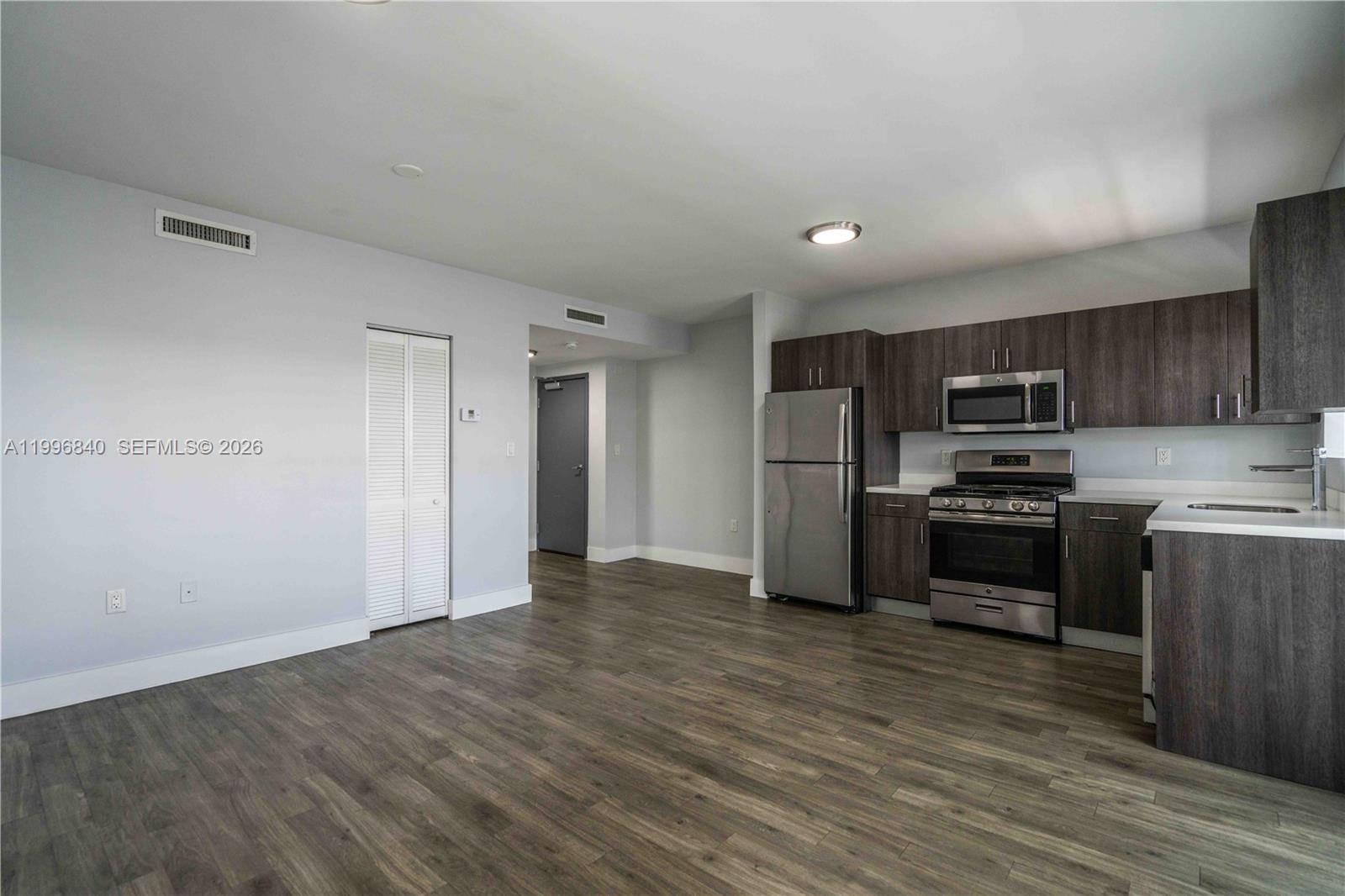 331 85th Street, Unit 17 Miami Beach, FL 33141 - Photo 6 of 16 a kitchen with granite countertop a refrigerator and a stove top oven