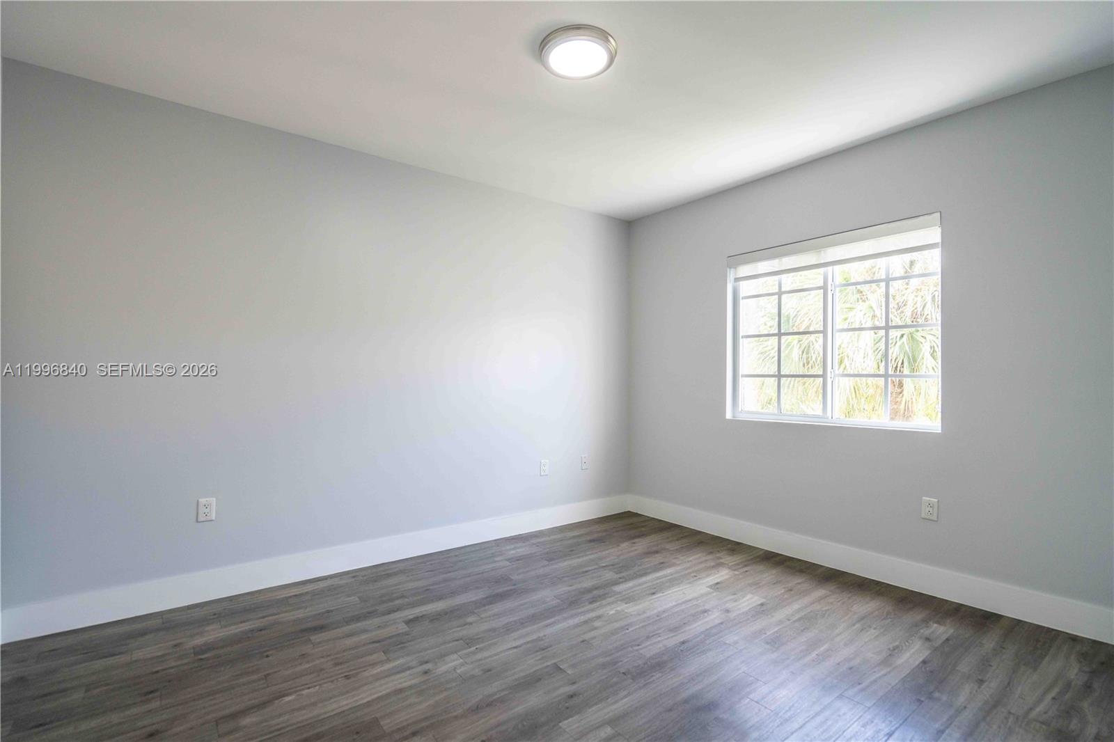 331 85th Street, Unit 17 Miami Beach, FL 33141 - Photo 8 of 16 an empty room with wooden floor and windows