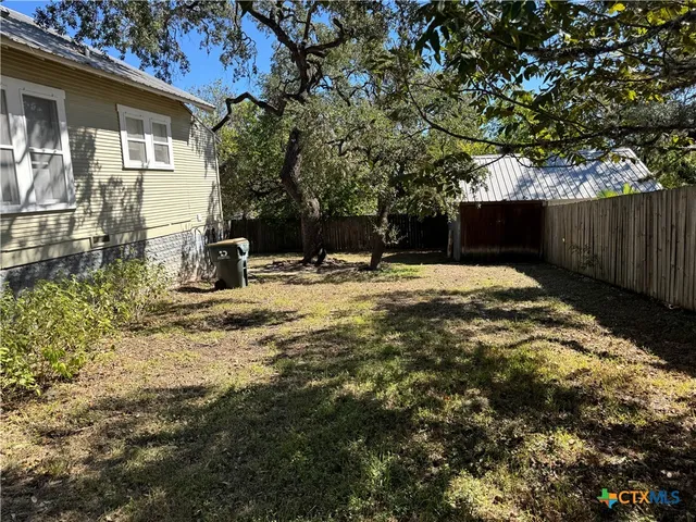a backyard of a house with table and chairs