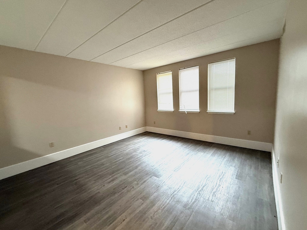 34 Sumner Avenue, Unit 208 Springfield, MA 01108 - Photo 3 of 7 a view of an empty room with wooden floor and a window