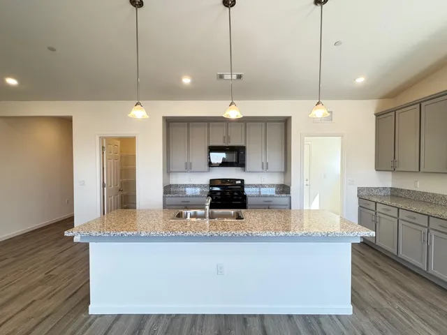 a large kitchen with kitchen island a large counter space a sink and appliances