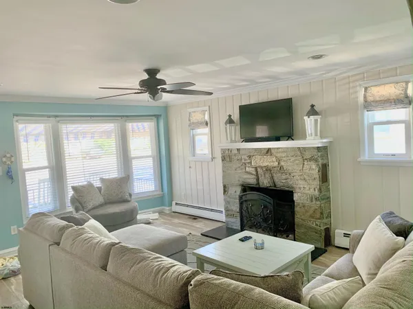 a living room with furniture a flat screen tv and a fireplace