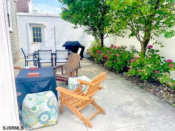 a view of a patio with furniture and a garden